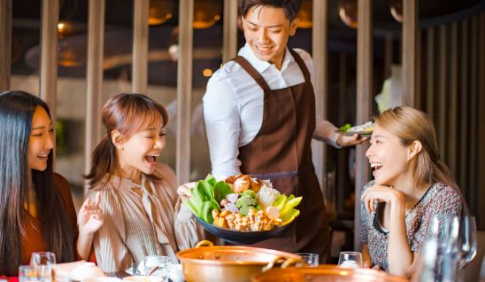 客席に運ばれてきた料理を見て喜ぶ客たち